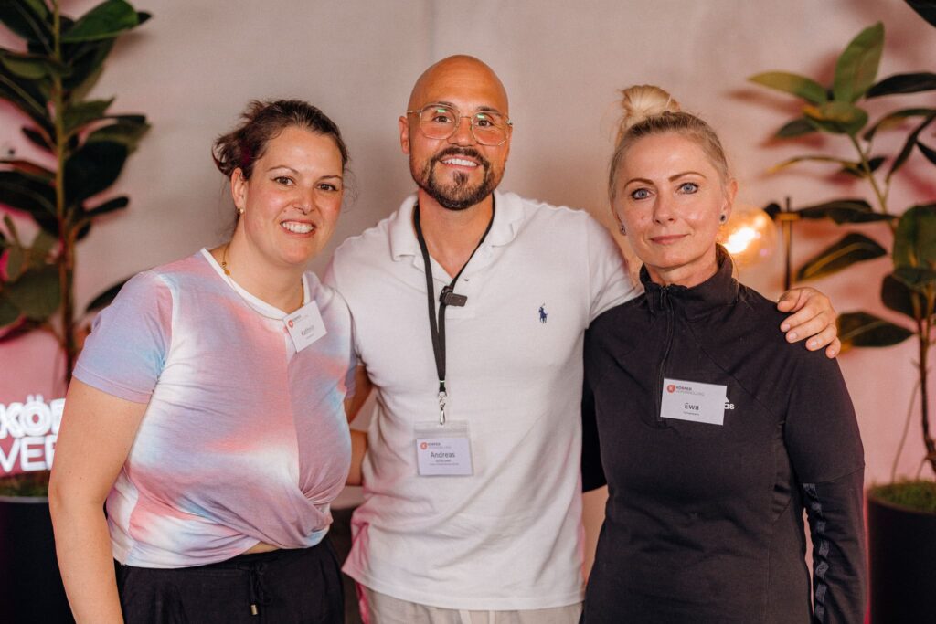 Ernährungsexperte Andreas Kotte von Körperverwandlung mit den Teilnehmerinnen Ewa und Kathrin, lächelnd bei einem gemeinsamen Körperanalyse Event.